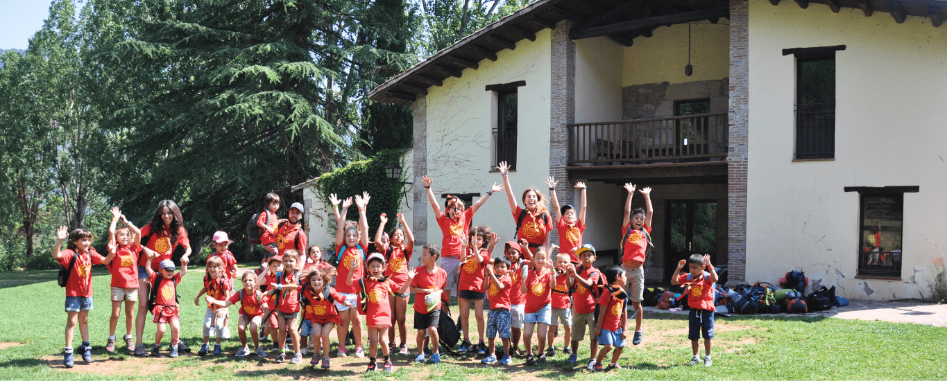 Grupo de niños y niñas frente a una casa de colonias Fundesplai