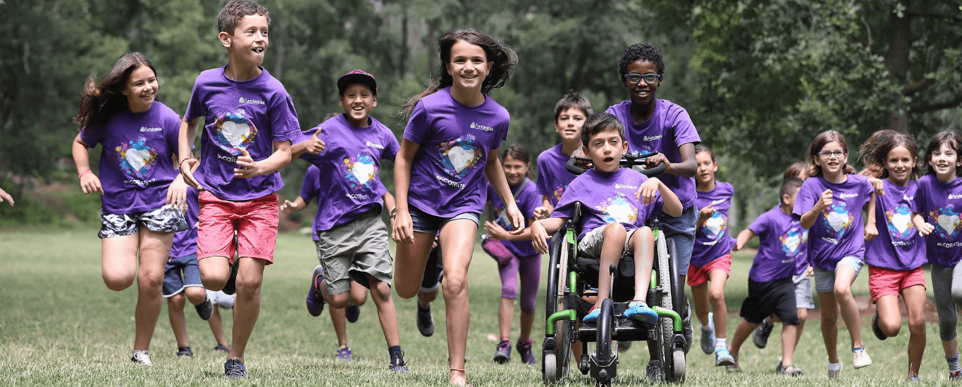 Grupo niños y niñas diversidad funcional corriendo alegres Fundesplai