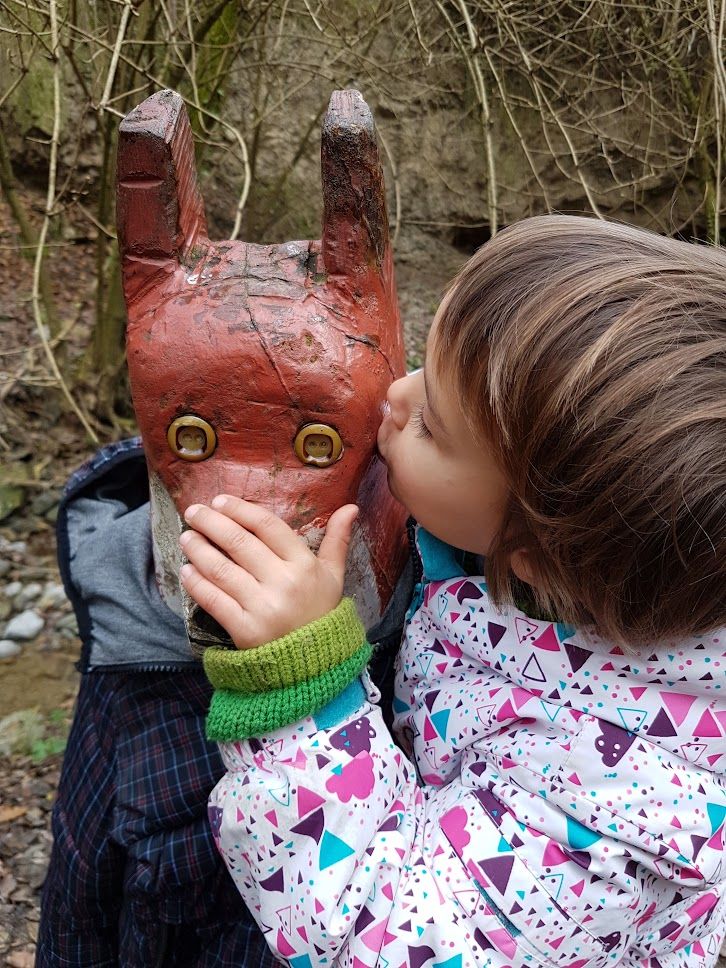 Nena fent un petó a una figura de fusta del Bosc Encantat de Gurb