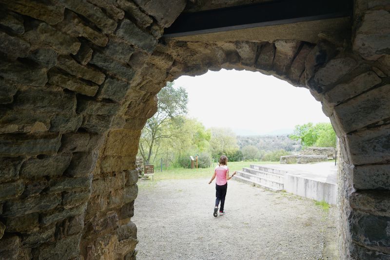 Niña de espaldas bajo arco Sant Pere Casserres