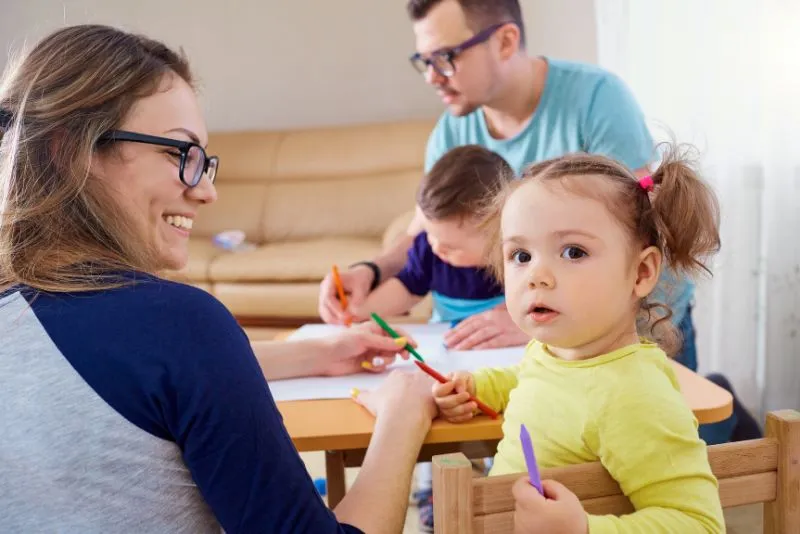 Família amb infants a casa fent dibuixos