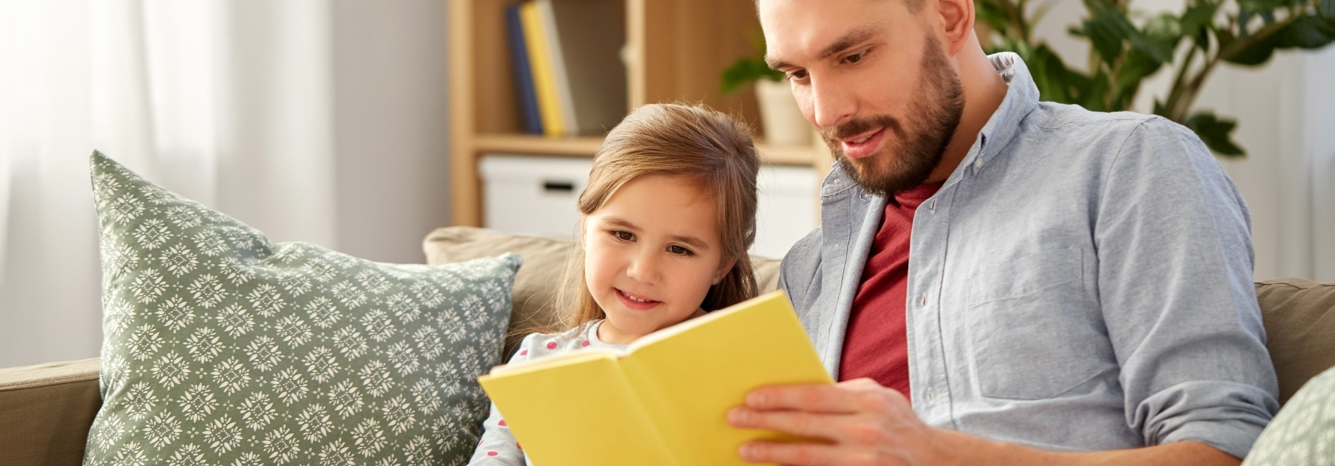 Pare i fill llegint un llibre a casa