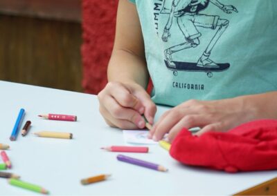 Pla detall de les mans d'un infant pintant amb llapis de colors
