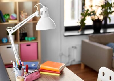 Escriptori de casa amb llum, llibres i bolígrafs
