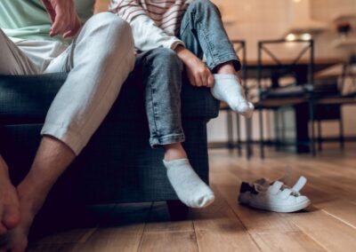 Pla detall d'adult i infant posant-se les bambes